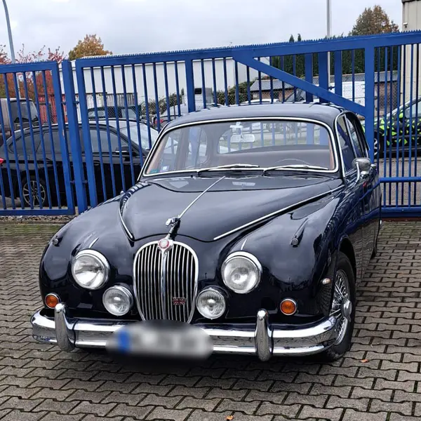 Jaguar MK2 Frontansicht vor dem blauen Werkstatttor der ACL Auto Company