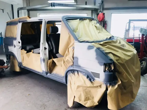 VW T4 Transporter in der Lackierkabine, abgeklebt und vorbereitet zur Lackierung